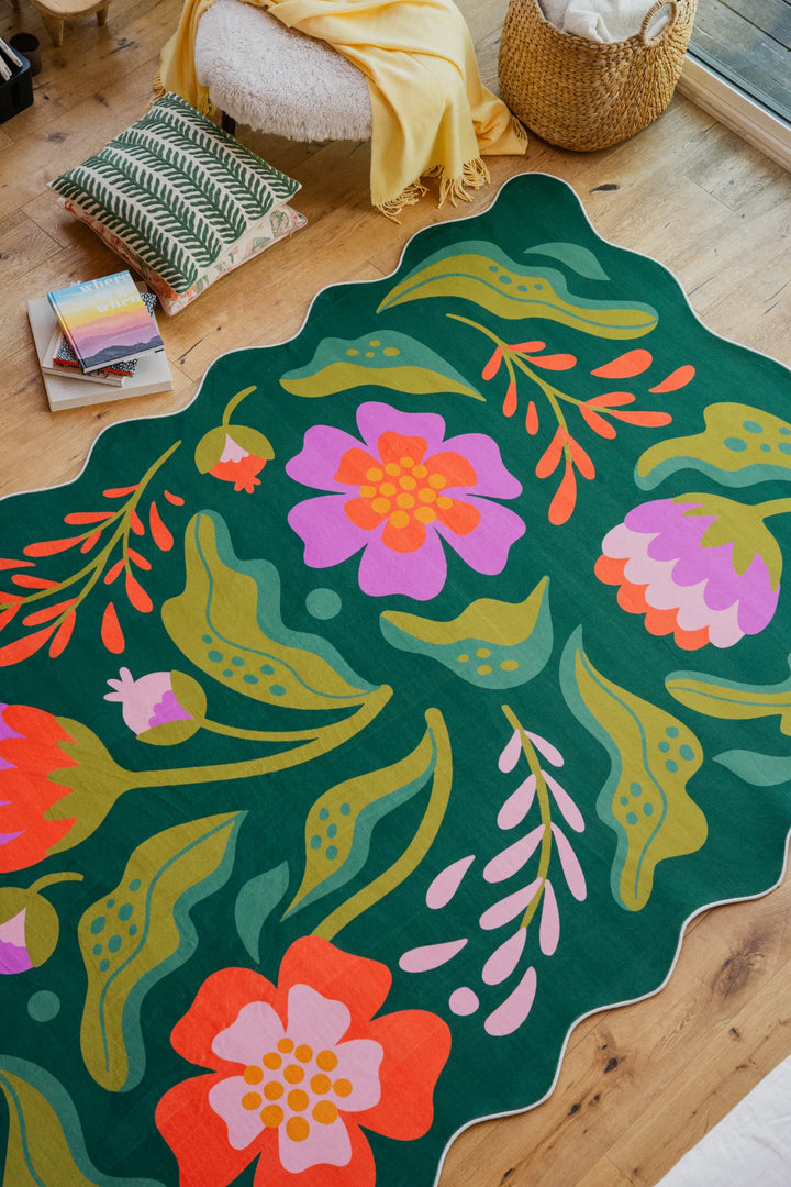 The wavy-edged green rug with pink floral details adds a fresh touch to the living room