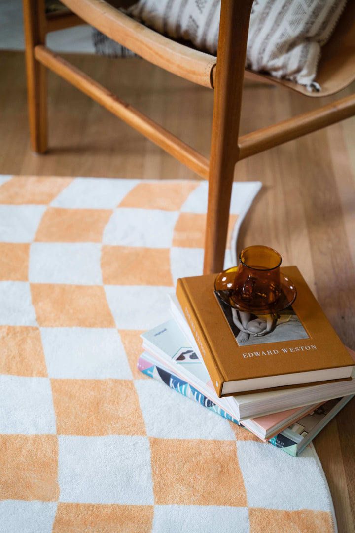 Books and a cup set on the LanySpace Yellow Wavy Checkered Rug