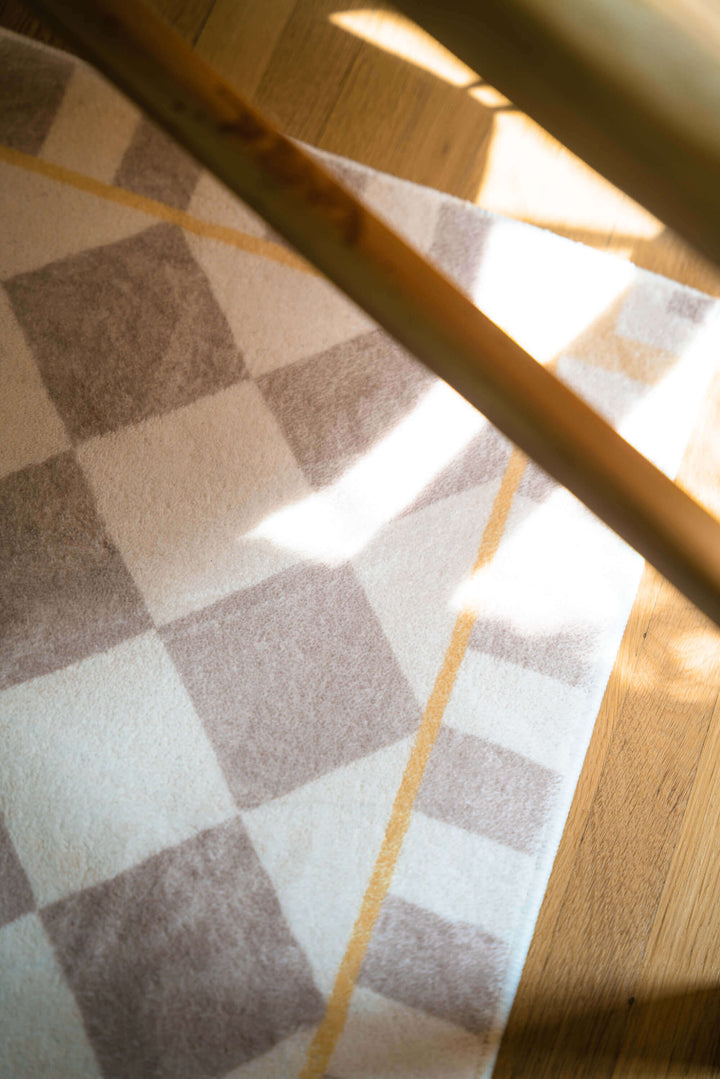 Beige and Cream Diamond Area Rug under the chair