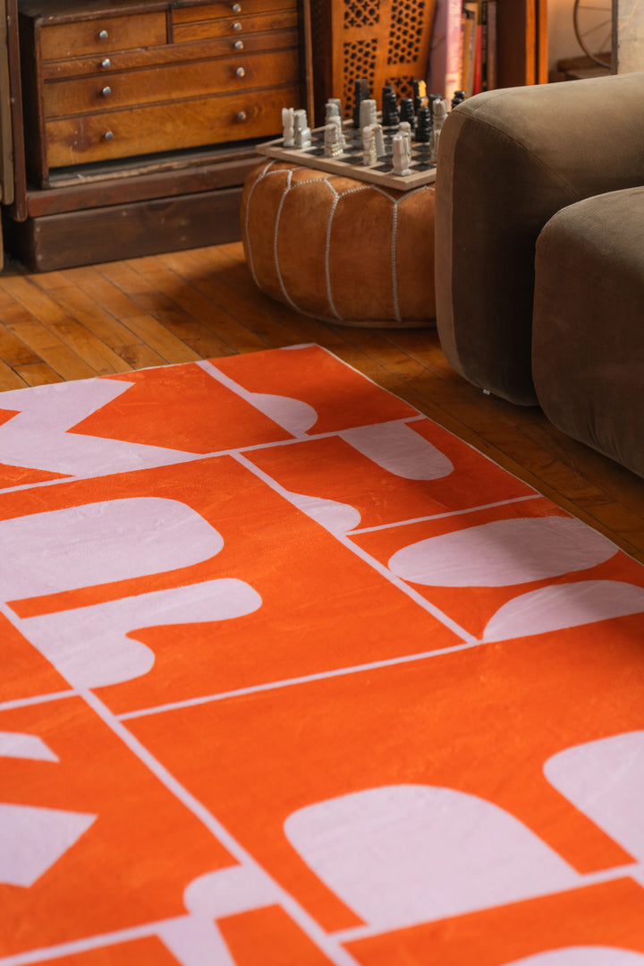 Orange Geometric Patchwork Rug with organic shapes styled beside a low modular seat, contemporary accent rug
