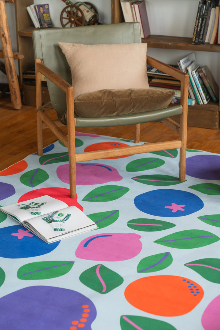 Colorful funky rug placed near a reading chair, bringing playful energy to a relaxed corner with wood floor