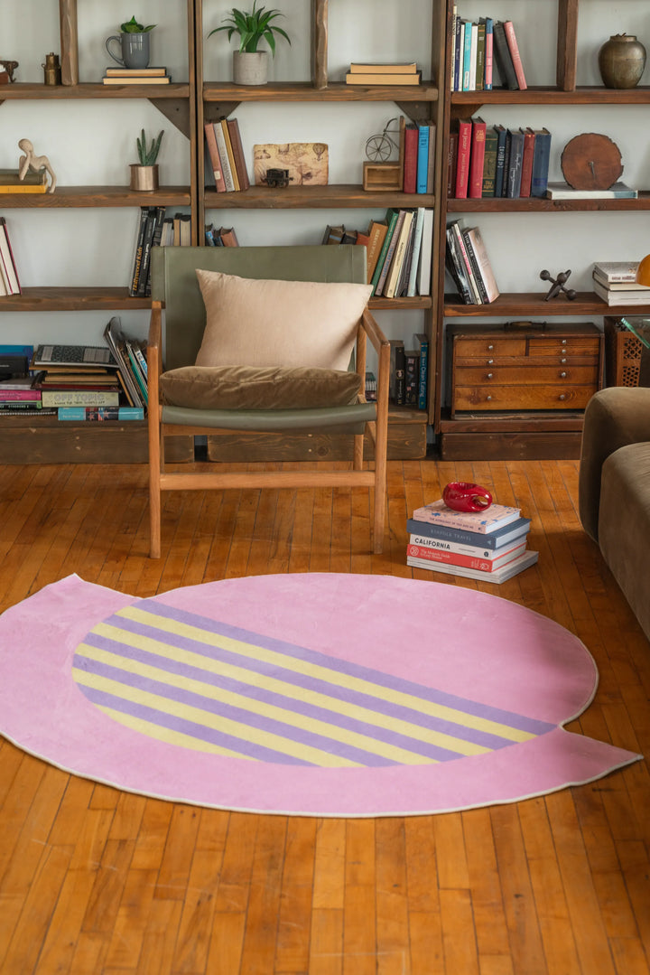 Pastel pink abstract circle rug with lilac and yellow stripes adds charm to a warm hardwood living room