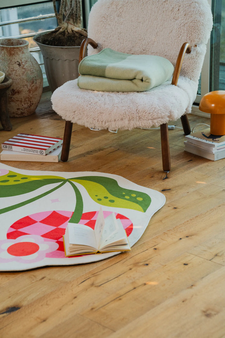 A cozy nook with Jessica Miller Irregular Pink and Red Checkered Cherry Rug